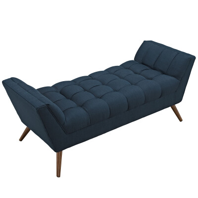 A blue upholstered bench with wooden legs.