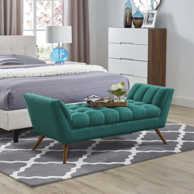 A teal upholstered bench in a bedroom.