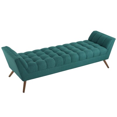 A teal upholstered bench with wooden legs.
