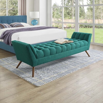A bedroom with a bed and a green upholstered bench.