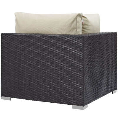 A black wicker lounge chair with a white cushion.