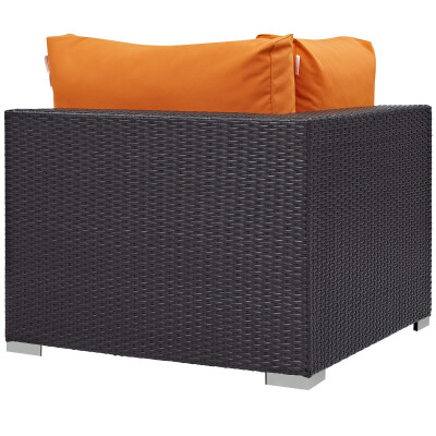 A black wicker lounge chair with orange cushions.