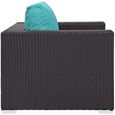 A black wicker lounge chair with a turquoise cushion.