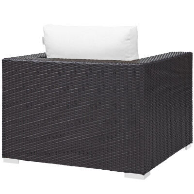 A black wicker lounge chair with a white pillow.