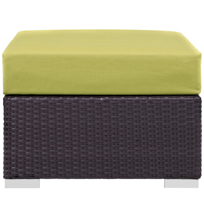 A wicker ottoman with a lime cushion.