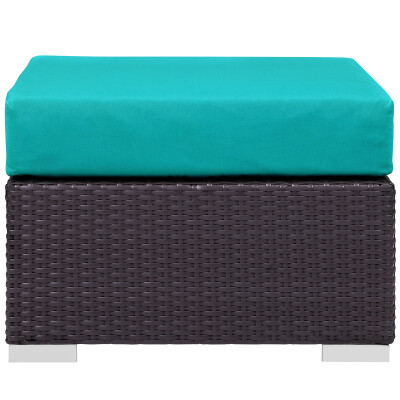 A wicker ottoman with a teal cushion.