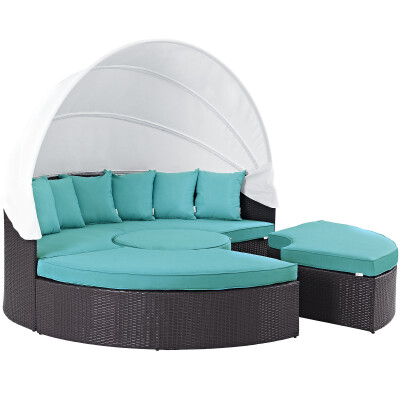 A rattan daybed with turquoise cushions.
