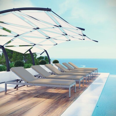A set of lounge chairs on a deck overlooking the ocean.