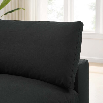 The back of a black couch with pillows.