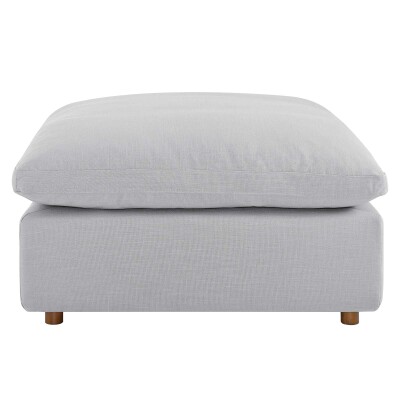 A grey ottoman with wooden legs on a white background.