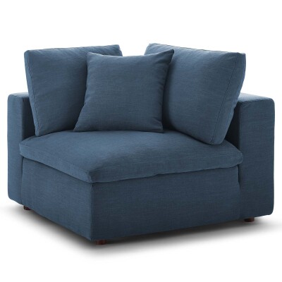 A blue corner chair with pillows.
