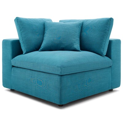 A blue corner chair with pillows on it.