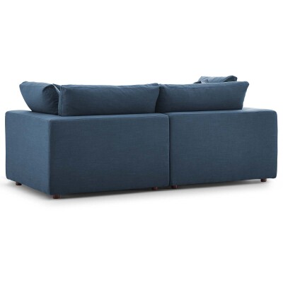 A blue couch with two pillows on it.