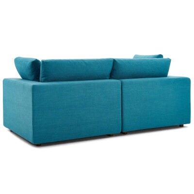 A blue sectional sofa with two pillows on it.