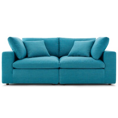 A blue sofa with pillows on a white background.