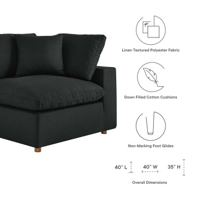 A black sectional sofa with a pillow and instructions.