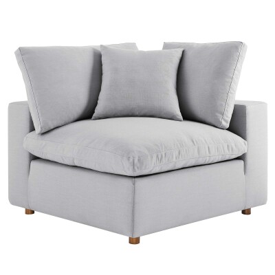 An image of a grey corner chair with pillows.