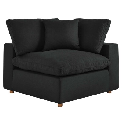 A black corner chair with two pillows.