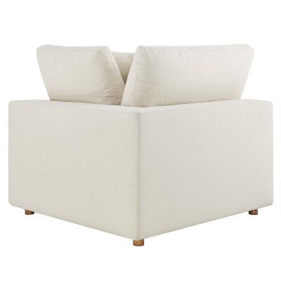 A white couch with two pillows on it.