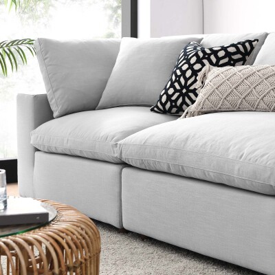 A white couch in a living room with a wicker basket.