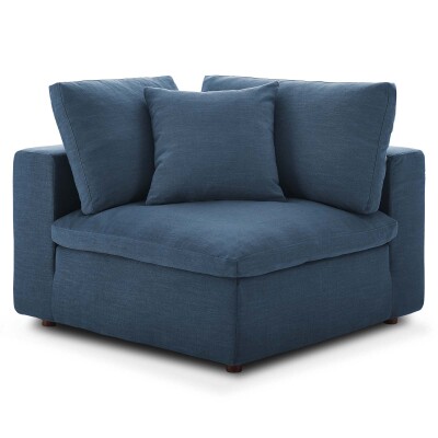 A blue corner chair with pillows.