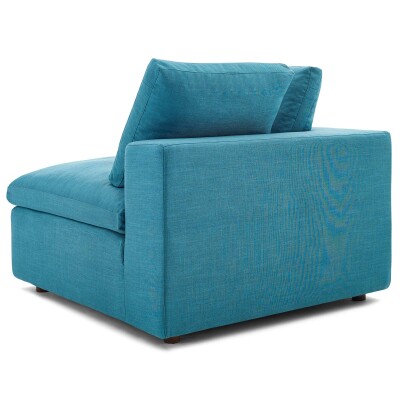 A teal couch with a cushion on it.