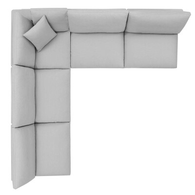 A grey sectional sofa with two pillows.