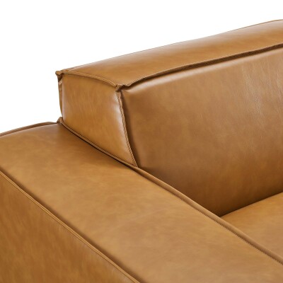 A close up image of a tan leather sofa.